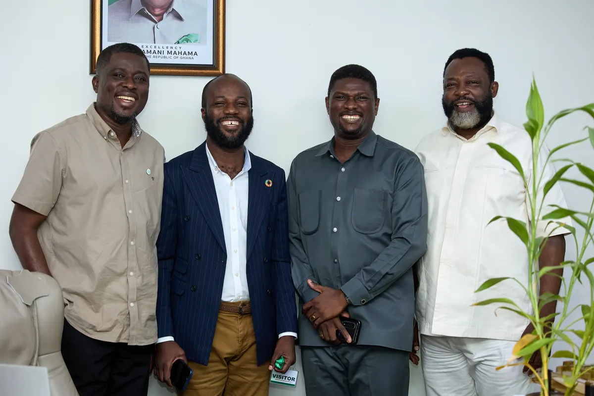 Four men standing together in an office.